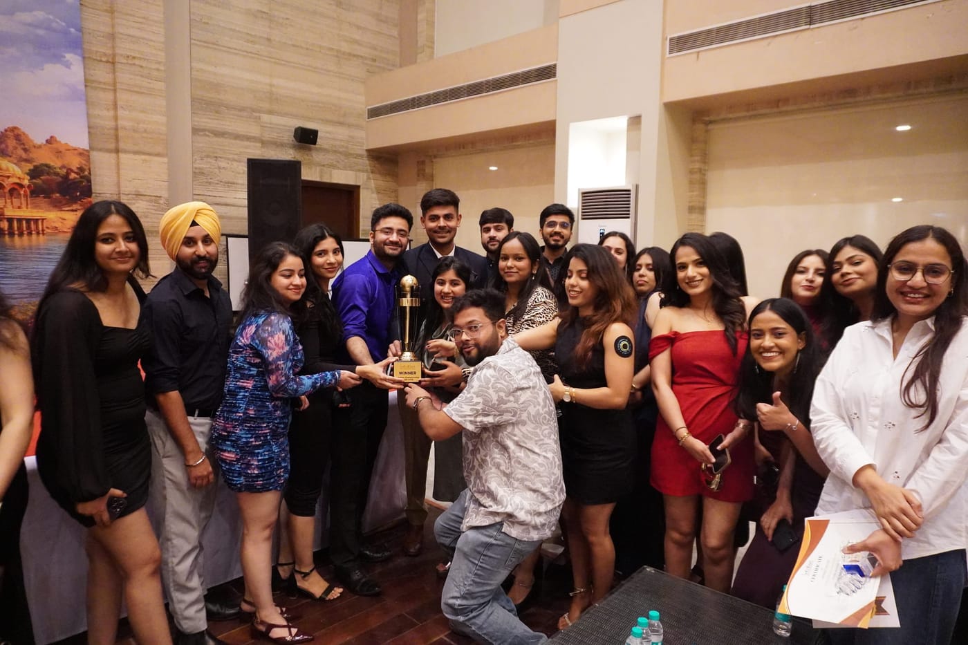 Infollion team members celebrating together holding a winners trophy.