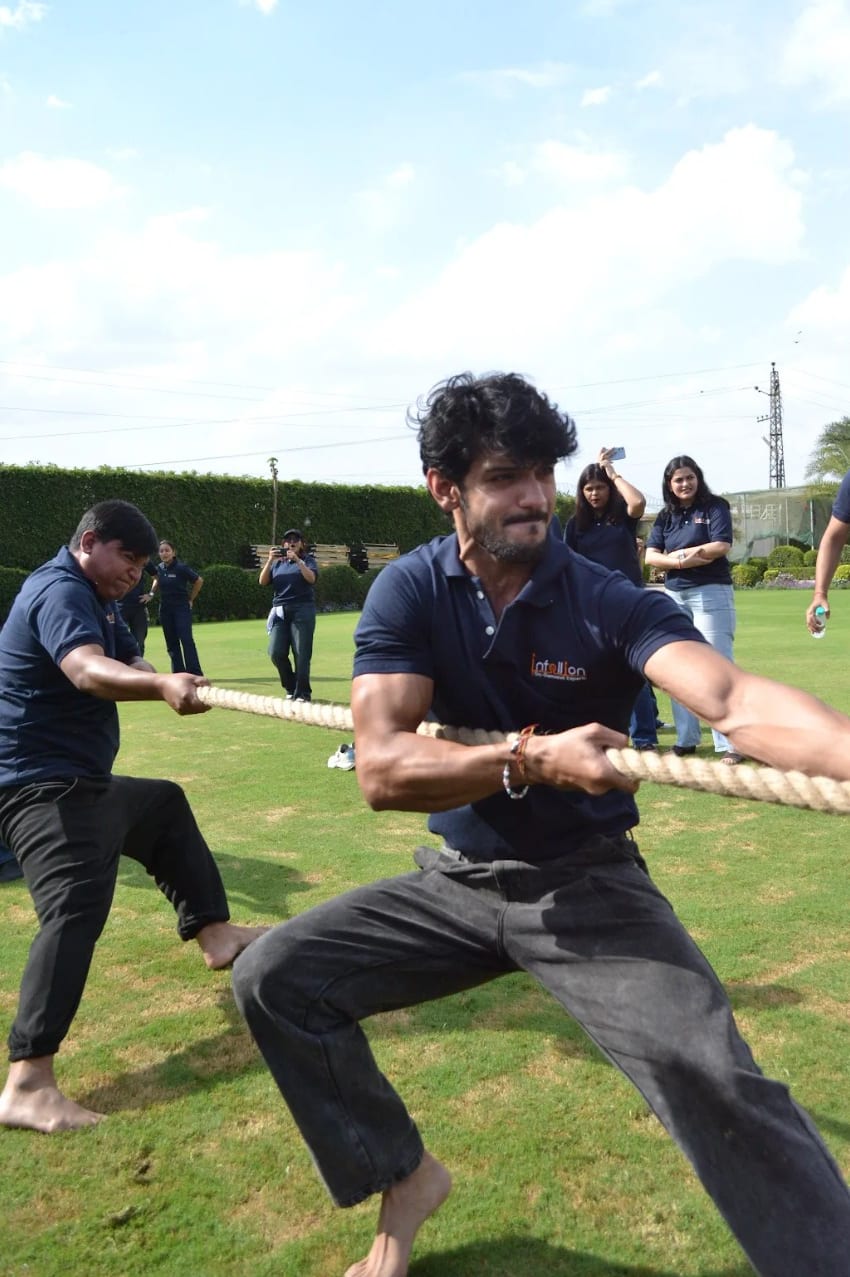 Infollion colleagues pulling on a rope during a tug-of-war.